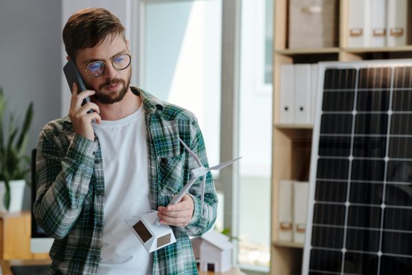 Green energy sales manager talking on phone with client